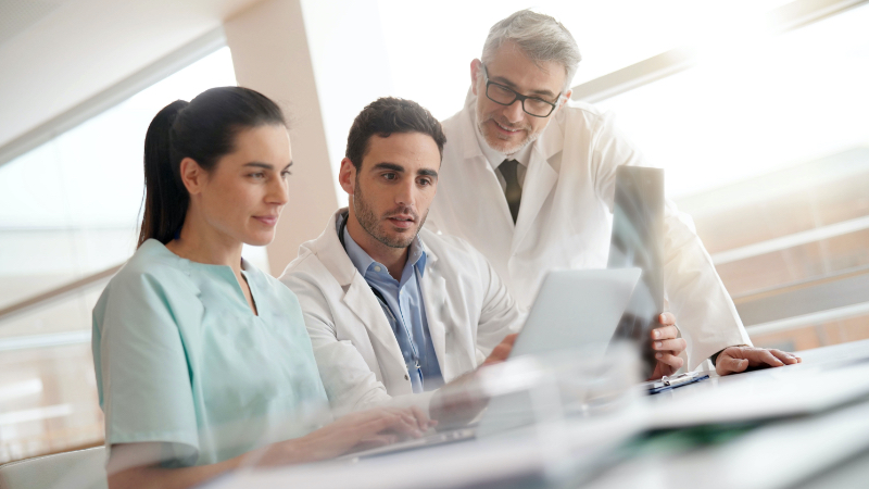 3 doctors reviewing something on a laptop